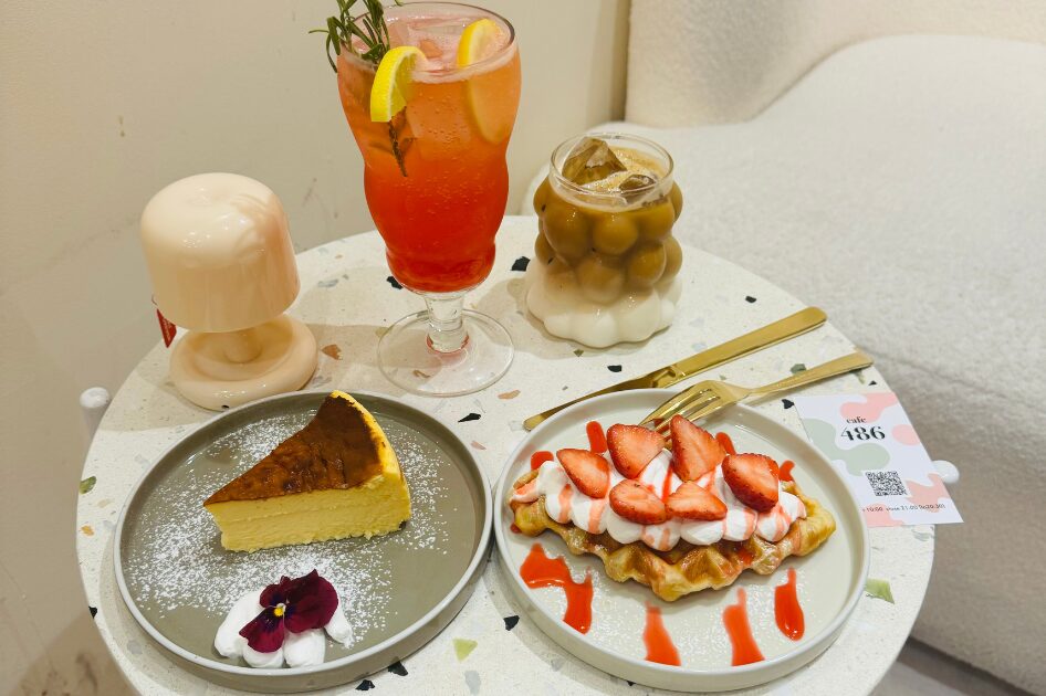 カフェ486のカフェテーブルの上に置かれたいちごクロッフルとベイクドチーズケーキ、カフェラテとピンクソーダ